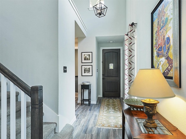 foyer with stairs, wood finished floors, and baseboards