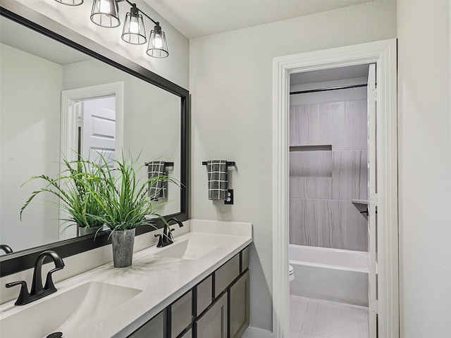 full bath featuring double vanity, toilet, and a sink