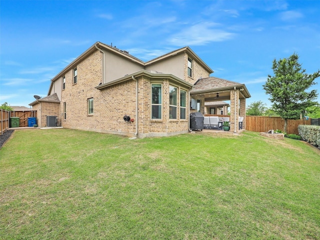 back of house with a fenced backyard, a patio area, and a yard