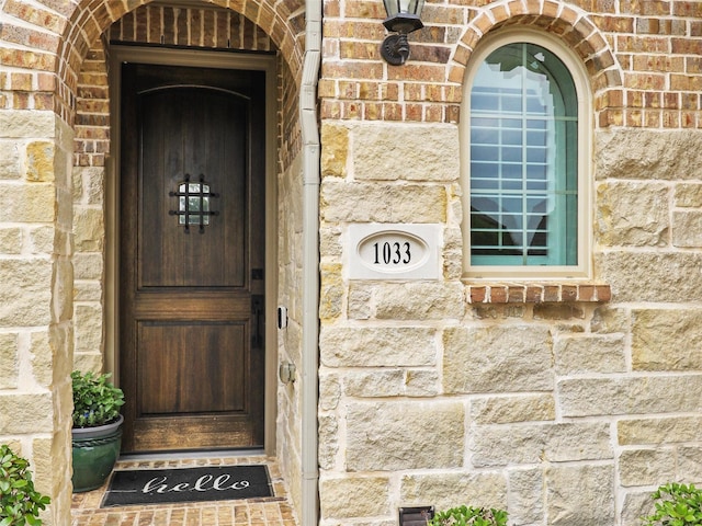 view of exterior entry with brick siding