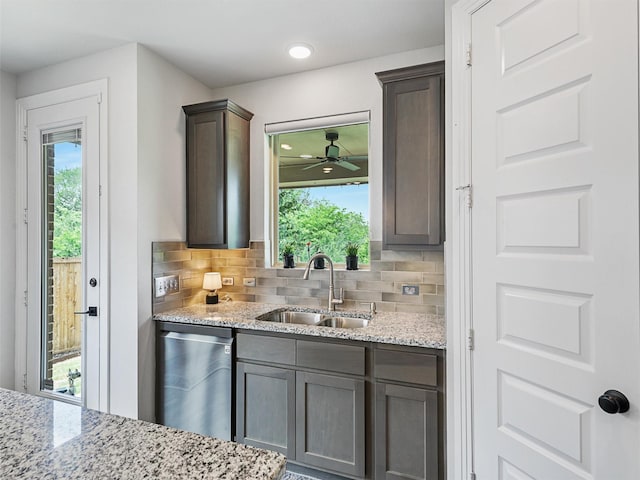 kitchen with stainless steel dishwasher, plenty of natural light, backsplash, and a sink