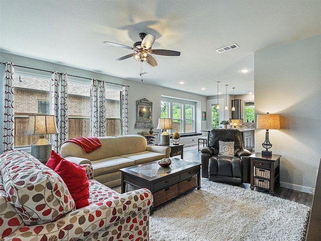 living area featuring visible vents, baseboards, recessed lighting, wood finished floors, and a ceiling fan