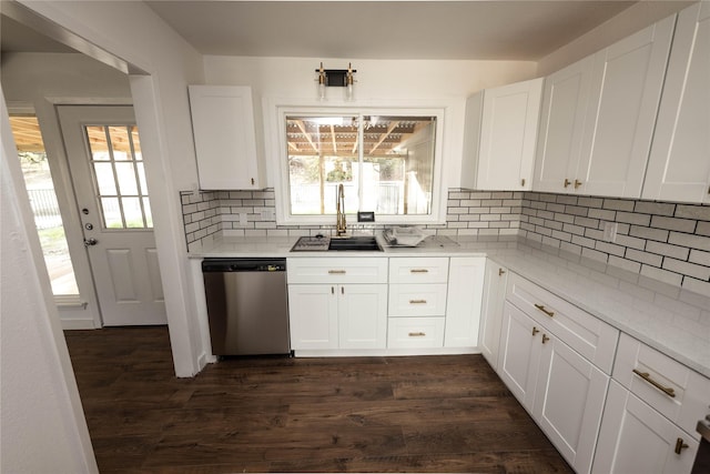 kitchen with sink, white cabinetry, tasteful backsplash, dark hardwood / wood-style flooring, and stainless steel dishwasher