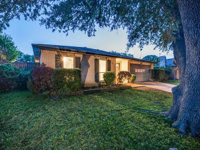 ranch-style home featuring brick siding, a garage, driveway, and a front yard