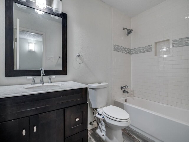 bathroom featuring toilet, shower / bath combination, wood finished floors, and vanity