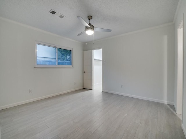 empty room with visible vents, a ceiling fan, light wood-style flooring, and ornamental molding