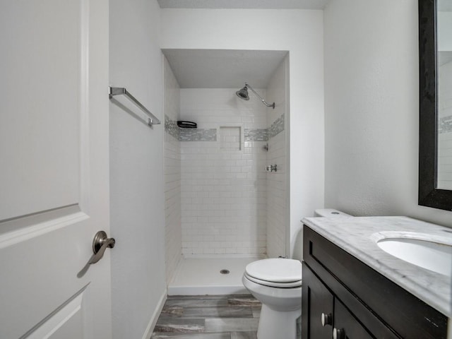 full bath with vanity, a stall shower, toilet, and wood finished floors
