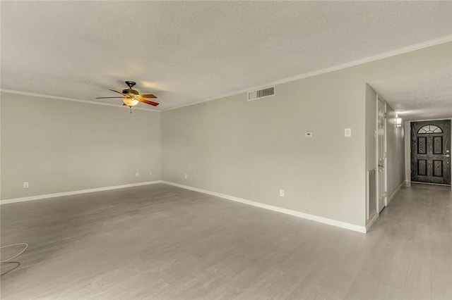 spare room featuring ceiling fan, crown molding, wood-type flooring, and a textured ceiling