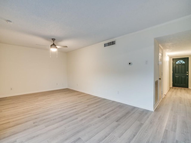 spare room featuring visible vents, light wood-style floors, ceiling fan, and baseboards