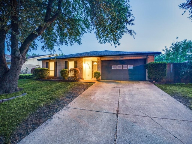 ranch-style house with a front yard, brick siding, fence, concrete driveway, and an attached garage
