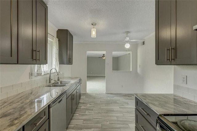 kitchen with sink, ceiling fan, appliances with stainless steel finishes, light stone counters, and a textured ceiling