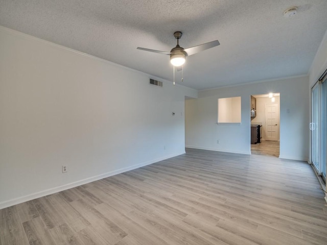 spare room with visible vents, crown molding, light wood-style floors, a textured ceiling, and a ceiling fan