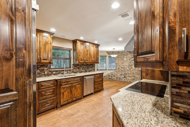 kitchen featuring sink, hanging light fixtures, stainless steel dishwasher, black electric cooktop, and light hardwood / wood-style flooring