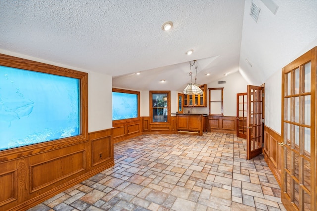 interior space with vaulted ceiling and a textured ceiling