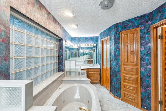 bathroom featuring vanity, a bathing tub, and a textured ceiling