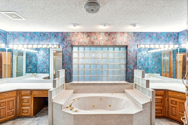 bathroom featuring shower with separate bathtub, vanity, and a textured ceiling