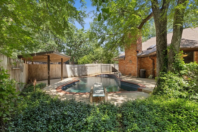 view of pool featuring a diving board and a patio