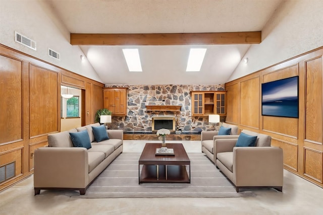 living room featuring beam ceiling, a skylight, high vaulted ceiling, a fireplace, and a textured ceiling