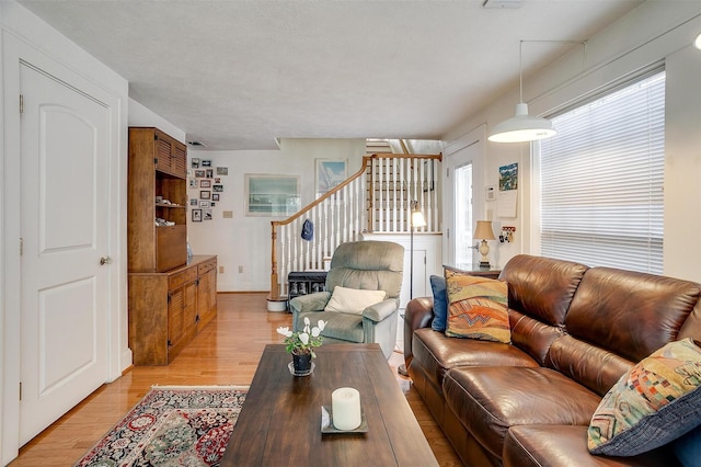 living room with light wood-type flooring and stairway