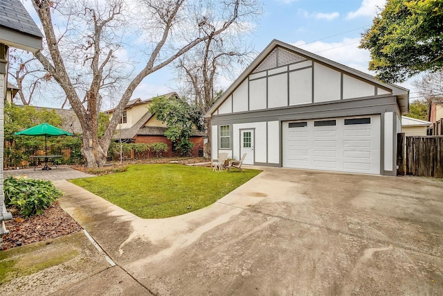 tudor home featuring driveway, fence, a front lawn, and board and batten siding