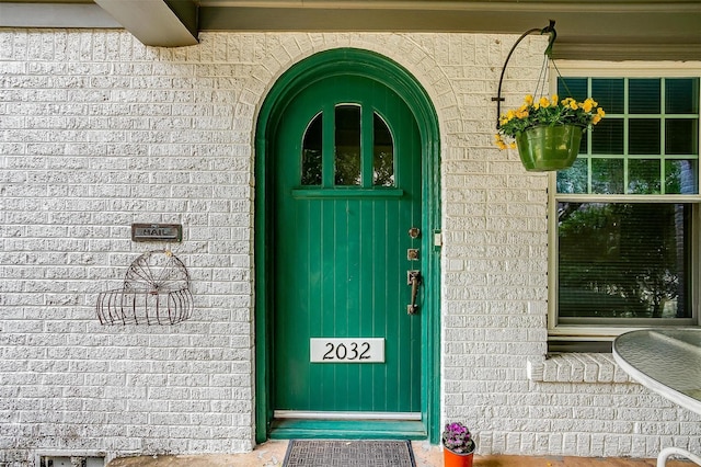 entrance to property featuring brick siding