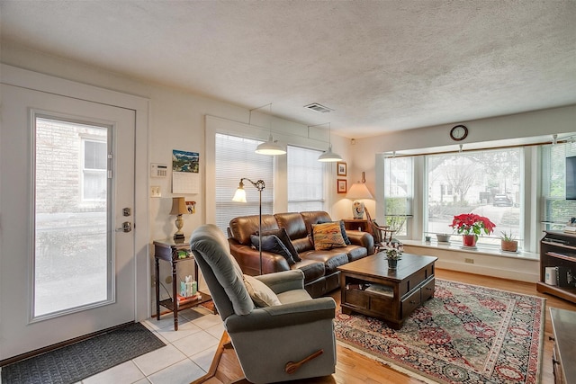 living area with visible vents and a textured ceiling