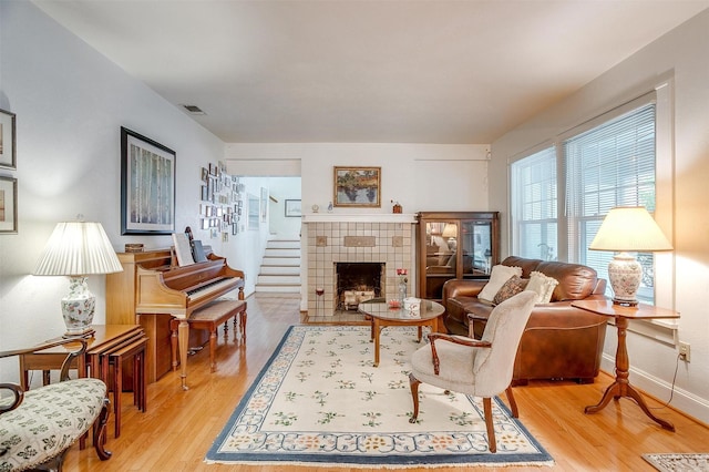 sitting room with light wood-style floors, baseboards, a fireplace, and visible vents