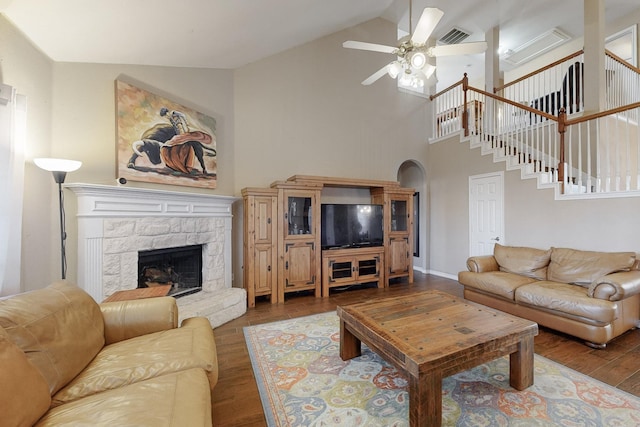 living room with a fireplace, dark hardwood / wood-style floors, ceiling fan, and vaulted ceiling