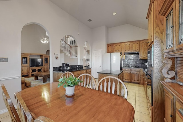 tiled dining room featuring high vaulted ceiling and ceiling fan