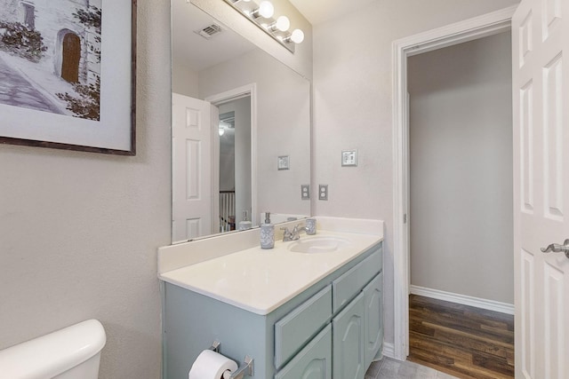 bathroom featuring vanity, wood-type flooring, and toilet