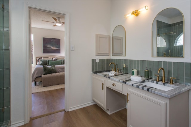 bathroom with a textured ceiling, vanity, ceiling fan, hardwood / wood-style floors, and decorative backsplash