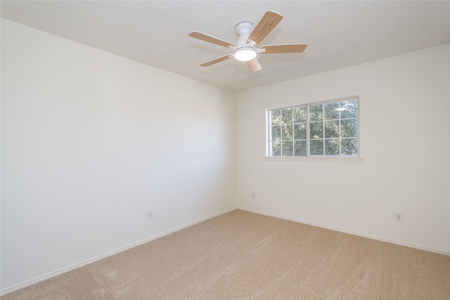 empty room featuring ceiling fan and light carpet