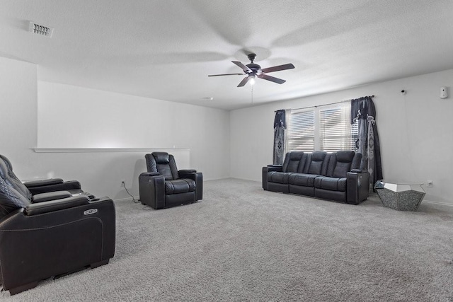 carpeted living room featuring a textured ceiling and ceiling fan