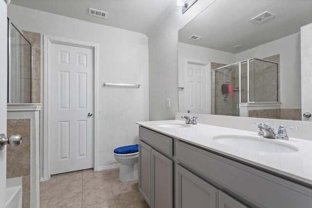 bathroom featuring tile patterned flooring, vanity, toilet, and walk in shower