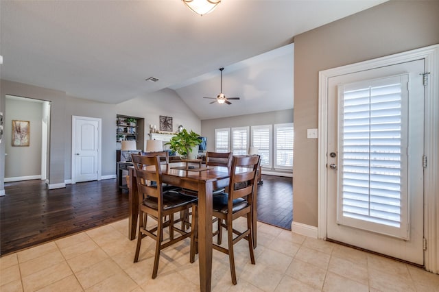 dining space featuring light tile patterned floors, baseboards, visible vents, a ceiling fan, and vaulted ceiling