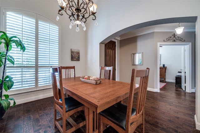 dining space with arched walkways, ornamental molding, dark wood-type flooring, and baseboards