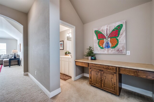 hallway featuring a skylight and light carpet