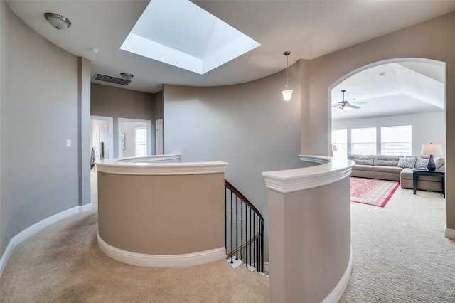 hall featuring baseboards, carpet flooring, and an upstairs landing