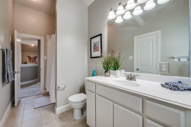 bathroom featuring toilet, vanity, baseboards, and tile patterned floors