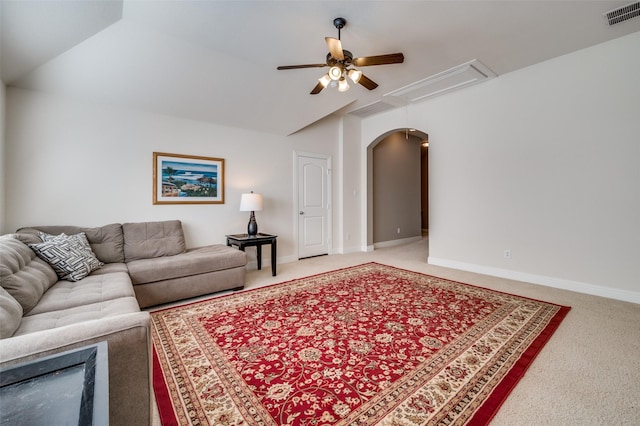 living area with attic access, visible vents, vaulted ceiling, and carpet floors