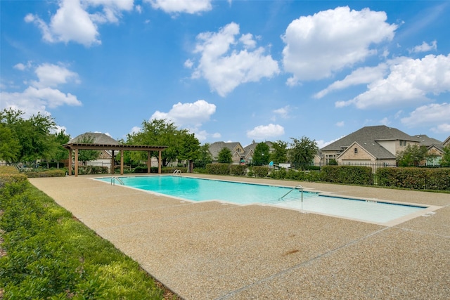 community pool with a patio area, fence, and a pergola