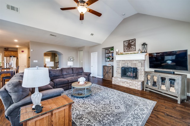 living room with arched walkways, a fireplace, wood finished floors, and visible vents