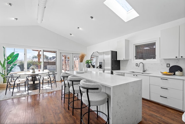 kitchen featuring sink, a kitchen island, white cabinets, and appliances with stainless steel finishes