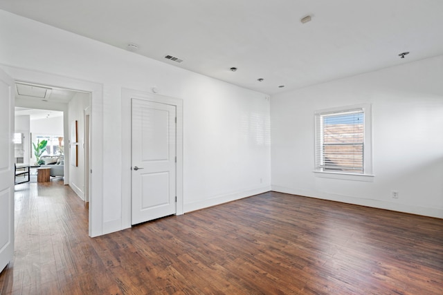 spare room with plenty of natural light and dark hardwood / wood-style floors