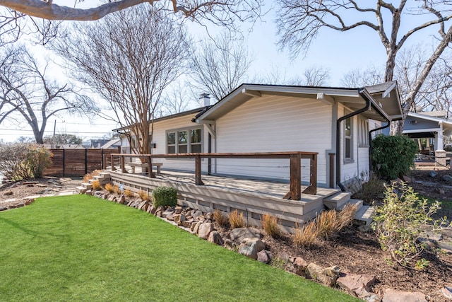 rear view of house featuring a lawn and a deck