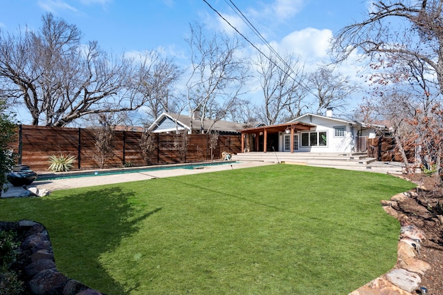 rear view of house featuring a patio, an empty pool, and a lawn