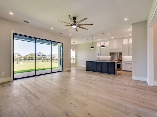 1165 Stonebridge Pass, Gunter, TX 75058 - unfurnished living room with baseboards, recessed lighting, ceiling fan, light wood-type flooring, and a sink