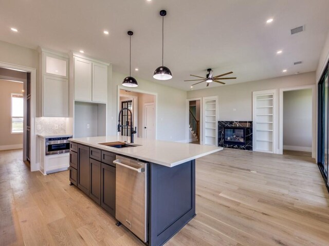 1165 Stonebridge Pass, Gunter, TX 75058 - kitchen featuring dishwasher, a sink, white cabinets, light countertops, and light wood-type flooring
