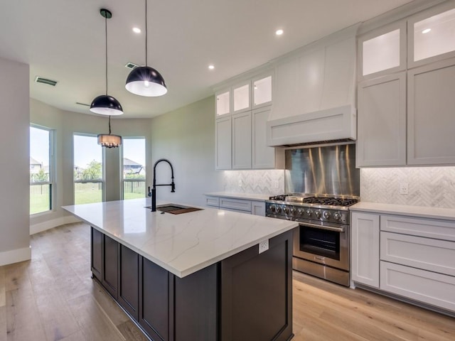1165 Stonebridge Pass, Gunter, TX 75058 - kitchen featuring high end range, a sink, an island with sink, backsplash, and recessed lighting