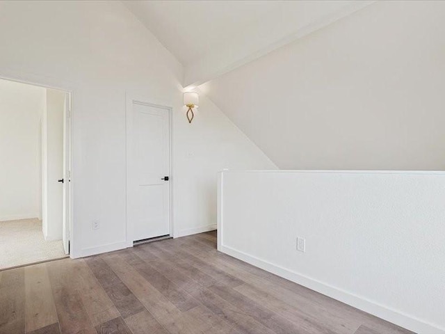 bonus room featuring vaulted ceiling and light hardwood / wood-style flooring